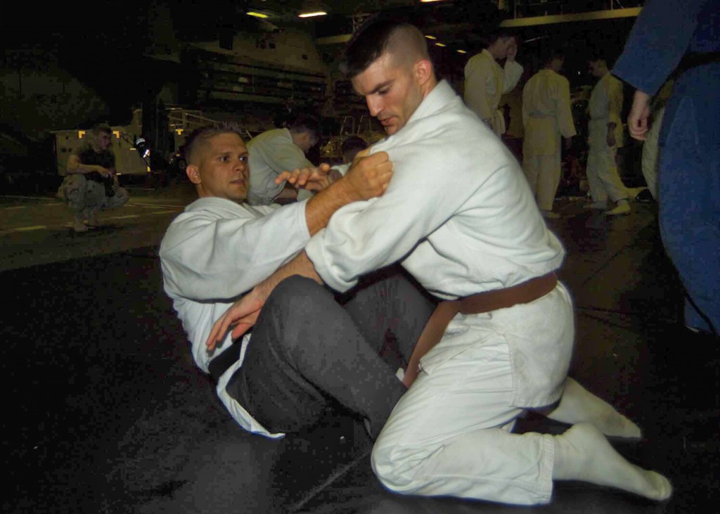 Lance Cpl Aaron Jacobs graples with 1stLt. Steve Gaspar during Judo training held in the hangar bay aboard the USS Nassau.